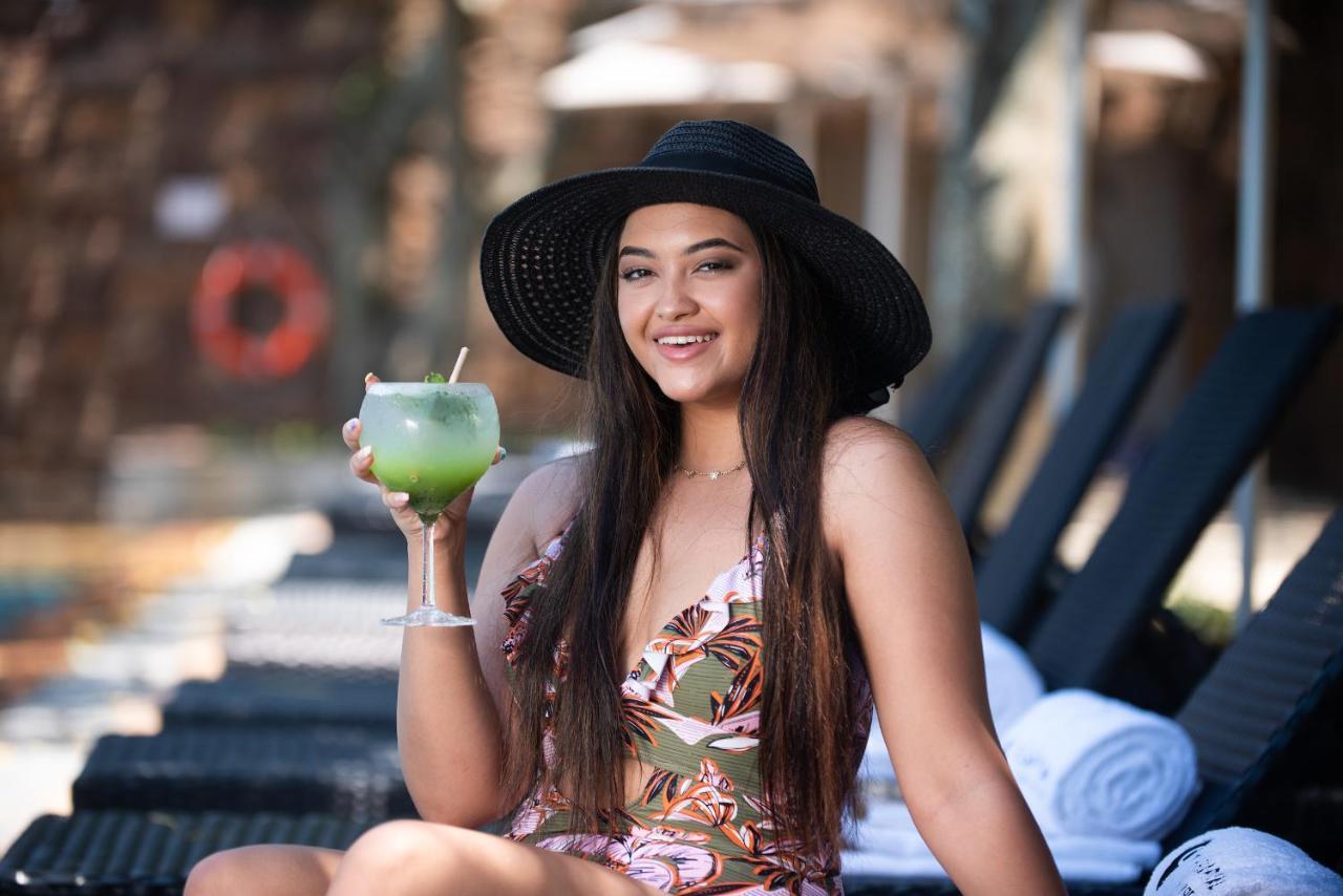 The Capital Zimbali 호텔 발리토 외부 사진 A woman wearing a sun hat