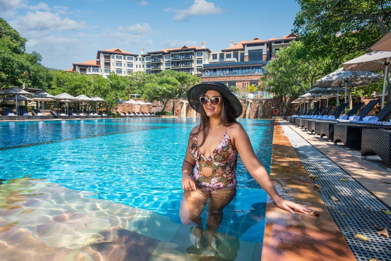 The Capital Zimbali 호텔 발리토 외부 사진 A woman wearing a sun hat